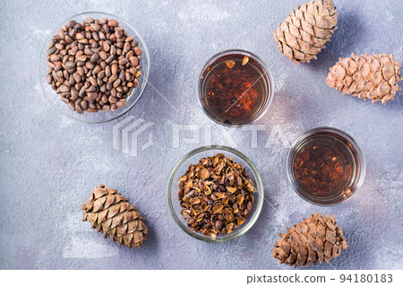 Infusion of pine nut shells in glasses and pine nuts on the table. Alternative medicine. Top view 94180183