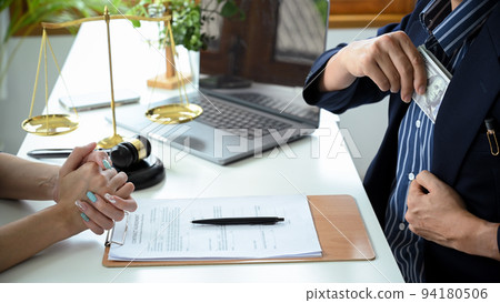 A businessman giving tribute money to his lawyer offers an illegal payment. A businessman giving tribute money to his lawyer offers an illegal payment. 94180506