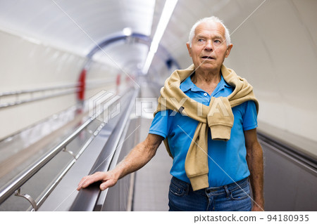 Retired man walking down the escalator to metro station Retired man walking down the escalator to metro station 94180935