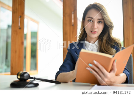 Charming young Asian female lawyer or business legal consultant with her law book. Charming young Asian female lawyer or business legal consultant with her law book. 94181172