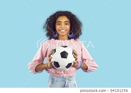 Smiling biracial teen girl with football ball 94181256