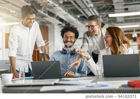 Busy coworkers cooperating and working together at office meeting, teamwork concept Busy coworkers cooperating and working together at office meeting, teamwork concept 94182071