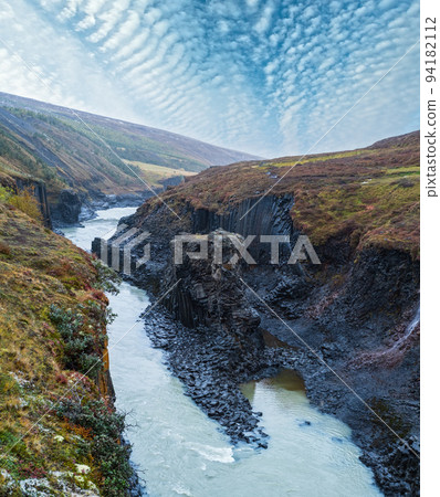 Autumn  picturesque Studlagil canyon is a ravine in Jokuldalur, Eastern Iceland. Famous columnar basalt rock formations and Jokla river runs through it. 94182112