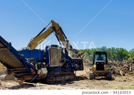 With the help of an industrial shredder machine, we are shredding the roots of the roots on the land being prepared for building housing developments 94183053