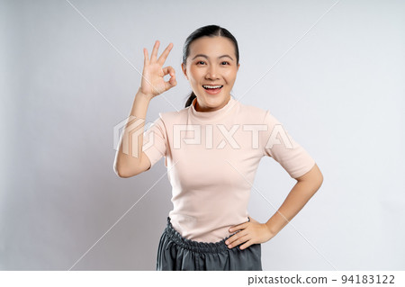 Happy woman showing OK gesture isolated on background. 94183122
