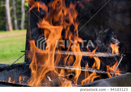 The preparation of the BBQ for grilling meat using firewood and blazing fires to prepare BBQ for grilling meat 94183123