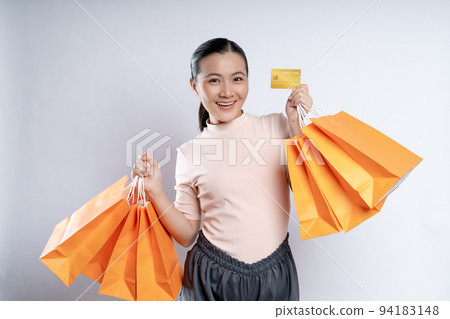 Asian woman happy smiling holding shopping bags and credit card isolated over white background. 94183148