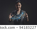 Asian woman showing a growing virtual hologram of statistics, graph and chart. 94183227