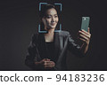 Asian woman scans face by smart phone using facial recognition system. 94183236
