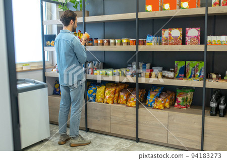 Shop owner putting products on the selves and looking involved 94183273