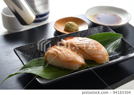 Broiled salmon nigiri sushi being grilled with a burner Broiled salmon nigiri sushi being grilled with a burner 94183304