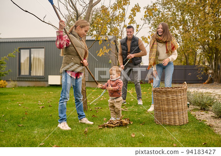 Young family doing the autumn yard cleanup Young family doing the autumn yard cleanup 94183427