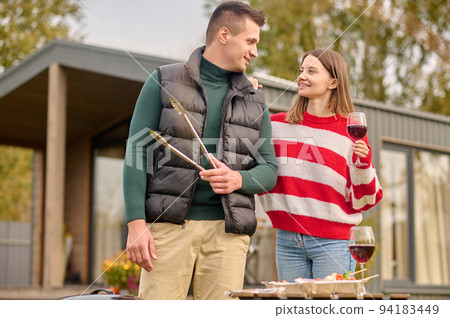 Joyous female and her companion having the barbecue party 94183449