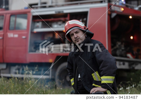 depressed and tired firefighter near fire truck.  94183487