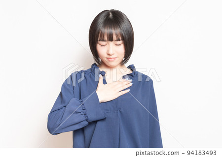 Young woman with her hand on her chest in front of a white background Young woman with her hand on her chest in front of a white background 94183493