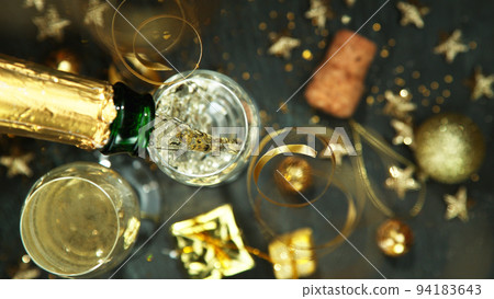 Champagne pouring in a glass from a bottle, top view. Champagne pouring in a glass from a bottle, top view. 94183643