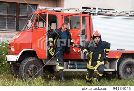 Group of fire fighters standing confident after a well done rescue operation. Firemen ready for emergency service. Group of fire fighters standing confident after a well done rescue operation. Firemen ready for emergency service. 94184046