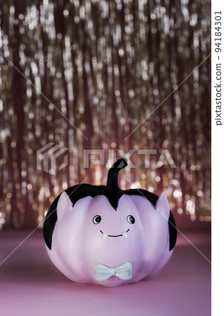 Funny and cute pink Vampire pumpkin with blue butterfly tie and golden tinsel curtain on the background. Halloween vertical card. Concept of entertainer, emcee for festive fall, autumn public events. Funny and cute pink Vampire pumpkin with blue butterfly tie and golden tinsel curtain on the background. Halloween vertical card. Concept of entertainer, emcee for festive fall, autumn public events. 94184301