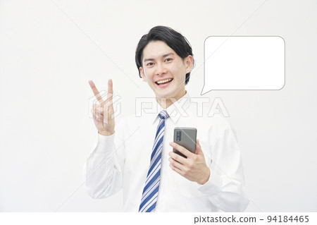 一個商人拿著智能手機，在白色背景上做一個和平標誌 94184465