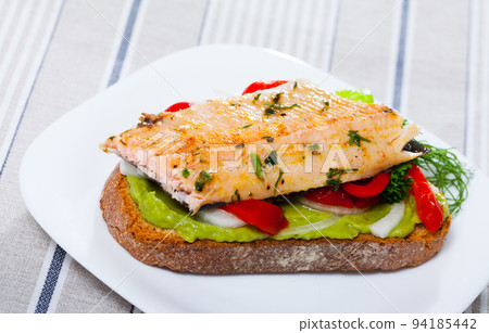Tasty piece of bread with fried trout fillet Tasty piece of bread with fried trout fillet 94185442