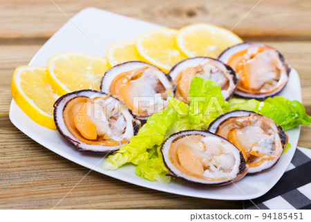 Image of salad of raw dog cockle with lemon and fresh greens 94185451