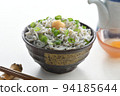 Whitebait rice bowl topped with ginger, chopsticks, soy sauce jug and raw egg (white background) 94185644