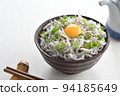 Whitebait rice bowl topped with egg, chopsticks and soy sauce jug 94185649