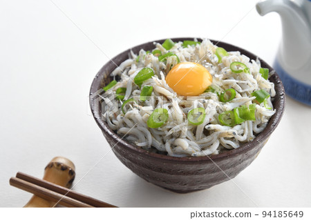 Whitebait rice bowl topped with egg, chopsticks and soy sauce jug 94185649