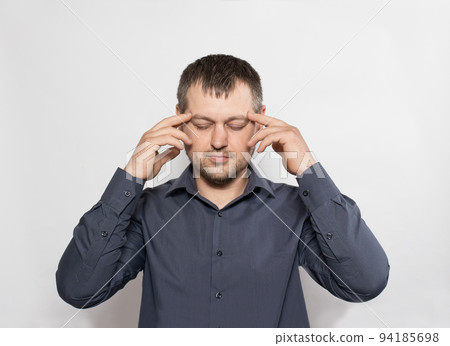 A man of 30 years holds his hands at his temples on a white background. 94185698