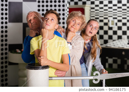 Grandparents and kids standing in row in escape room 94186175