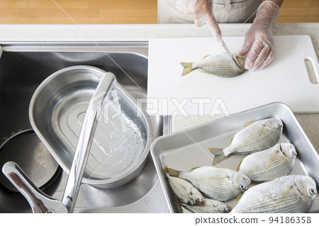 Japanese housewife cooking fish in the kitchen 94186358