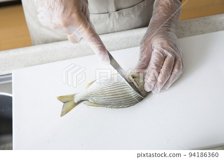 Japanese housewife cooking fish in the kitchen 94186360
