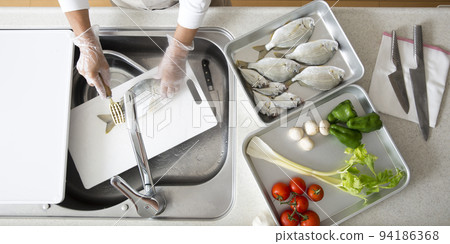 Japanese housewife cooking fish in the kitchen 94186368