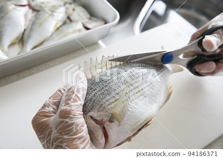 Japanese housewife cooking fish in the kitchen 94186371