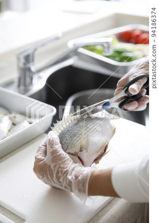 Japanese housewife cooking fish in the kitchen 94186374