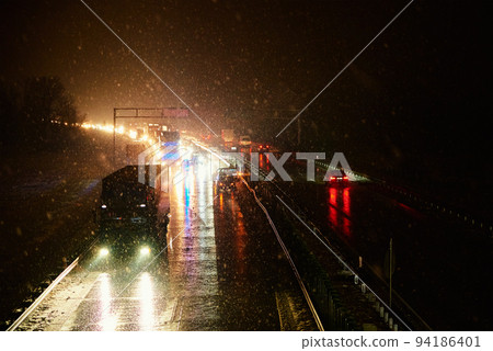 Car accident on slippery road at night during snowfall, Dangerous driving during winter snowstorm 94186401
