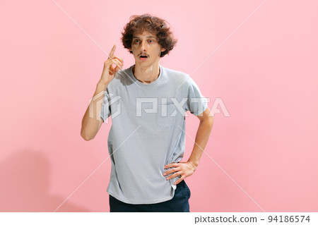 Portrait of young man with mustache posing with thoughtful expression, rising finger like having idea isolated over pink studio background Portrait of young man with mustache posing with thoughtful expression, rising finger like having idea isolated over pink studio background 94186574