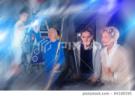 Girl and an elderly grandmother are trying to solve puzzle using computer to get out of quest during corporate event 94186595
