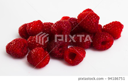 Close up of ripe red raspberries on white surface, no people Close up of ripe red raspberries on white surface, no people 94186751