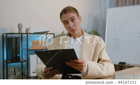 Business woman at home office analysing paperwork documents, shocked by sudden victory good news wow Business woman at home office analysing paperwork documents, shocked by sudden victory good news wow 94187231