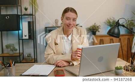 Businesswoman enters office start working on laptop computer at desk and drinking morning coffee 94187268