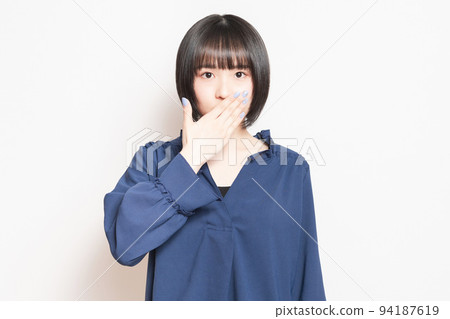 用手摀住嘴,擺出秘密姿勢的年輕女子 用手摀住嘴,擺出秘密姿勢的年輕女子 94187619