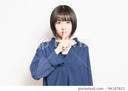 用手摀住嘴,擺出秘密姿勢的年輕女子 用手摀住嘴,擺出秘密姿勢的年輕女子 94187622