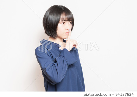 用手摀住嘴,擺出秘密姿勢的年輕女子 用手摀住嘴,擺出秘密姿勢的年輕女子 94187624
