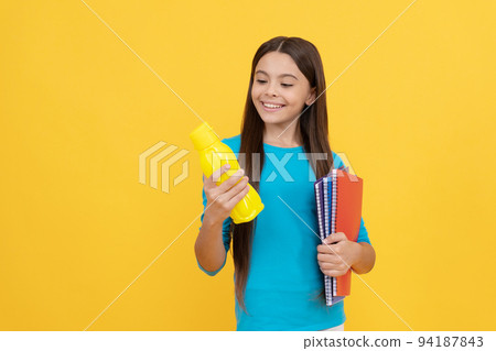 going to drink. cheerful kid with juice or water and books. smiling teenager student. 94187843
