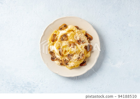 Pappardelle pasta with mushrooms, cream sauce and grated Parmesan cheese 94188510