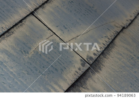 The faded and dirty roof of a 25-year-old detached house 94189063
