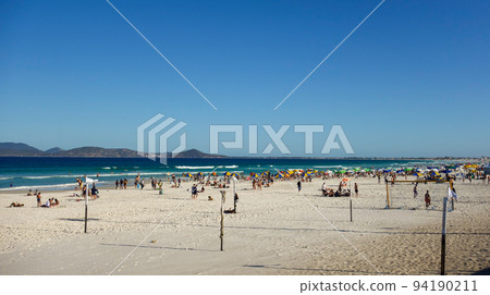 colorful umbrellas and tourists crowd the sand line at Praia do Forte in Cabo Frio, Rio de Janeiro, Brazil colorful umbrellas and tourists crowd the sand line at Praia do Forte in Cabo Frio, Rio de Janeiro, Brazil 94190211