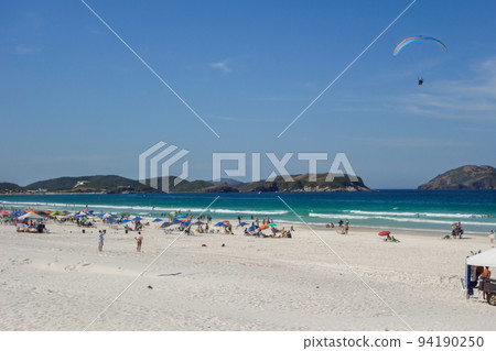 Paramotor flyes over Praia do Forte beach in Cabo Frio, Rio de Janeiro, Brazil 94190250