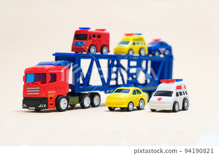 Toy car transporter with cars on a white background with place for text, copy space, for a toy store. Toy car transporter with cars on a white background with place for text, copy space, for a toy store. 94190821